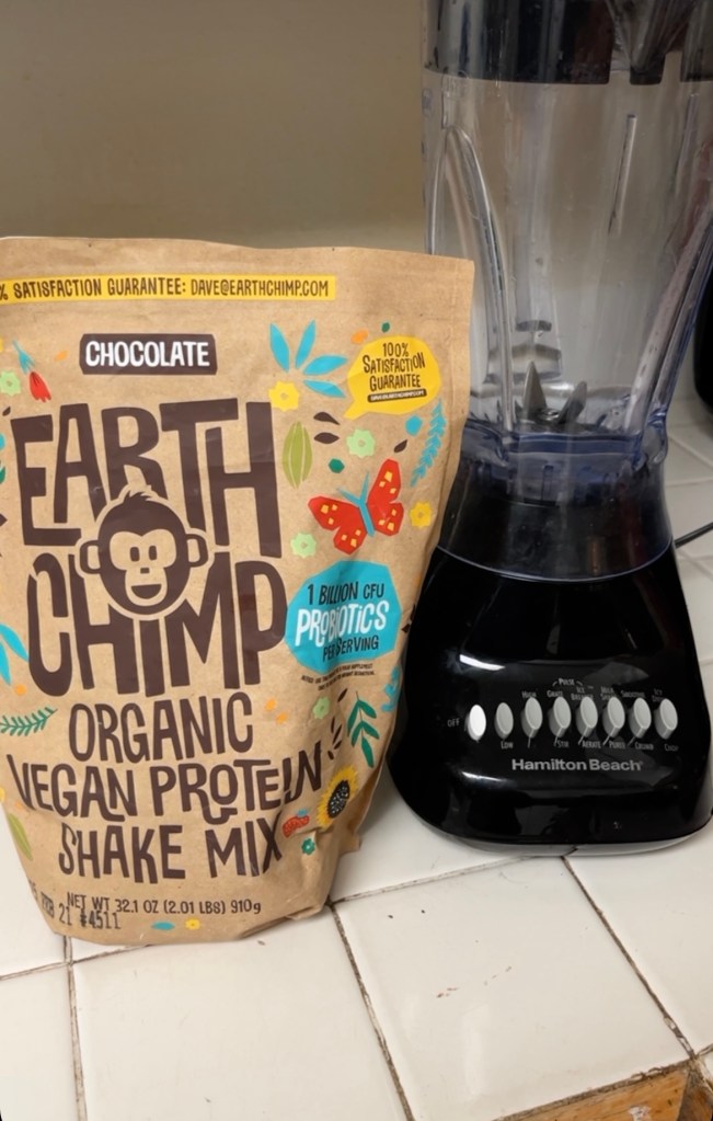 Earth Chimp Organuc Vegan Protein Shake Mix next to blender.